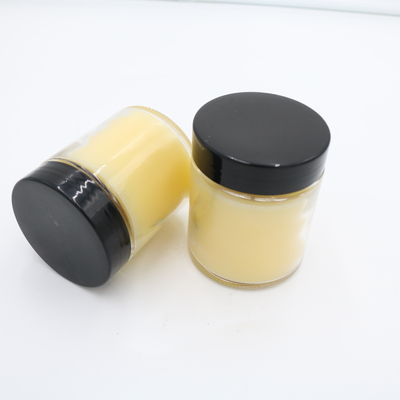 La mano profumata della candela del barattolo di vetro giallo della verbena del limone ha versato le candele della soia con il coperchio nero