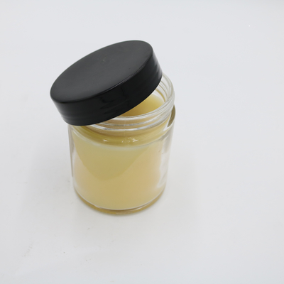La mano profumata della candela del barattolo di vetro giallo della verbena del limone ha versato le candele della soia con il coperchio nero